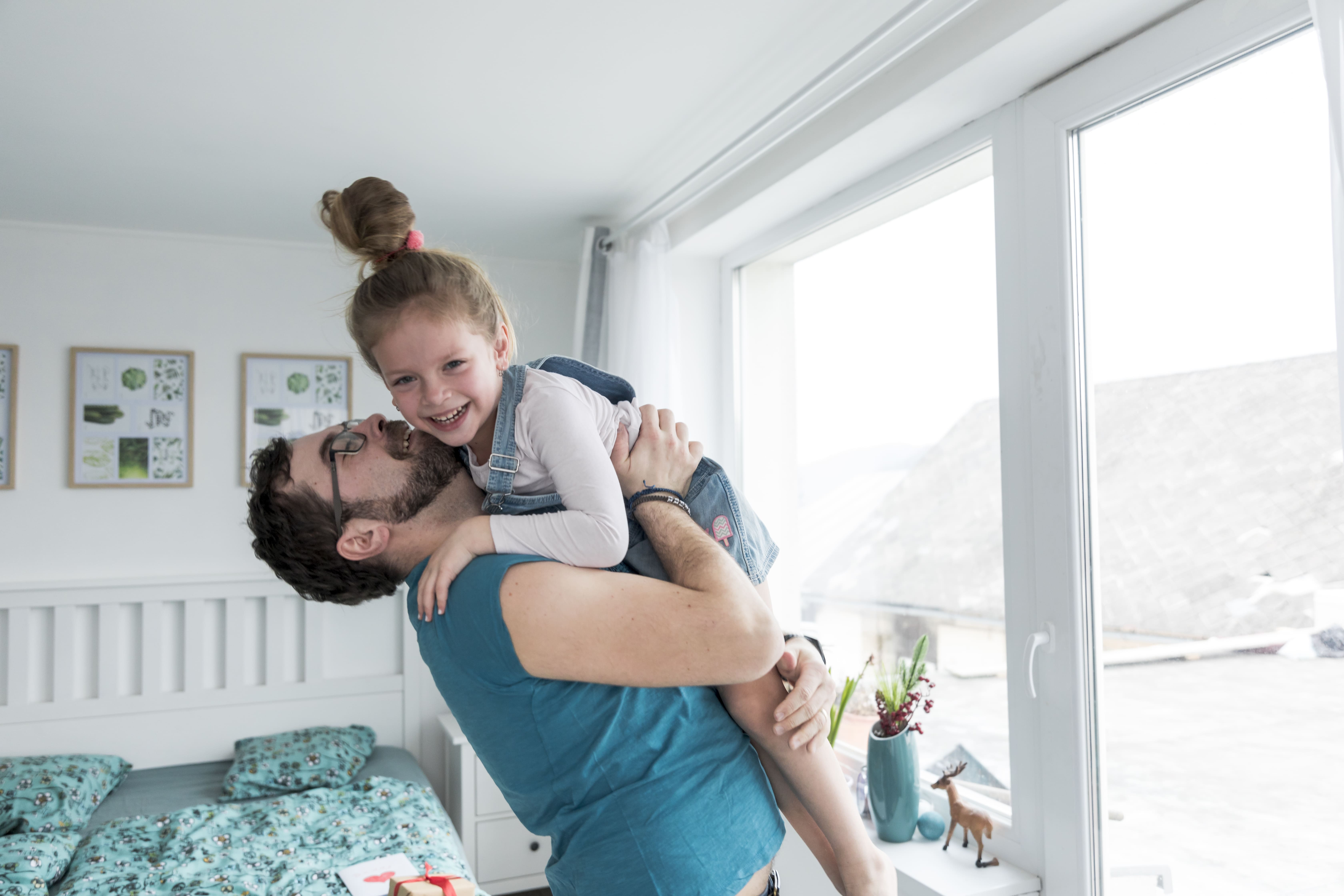 Pai a abraçar a filha, ambos a sorrir